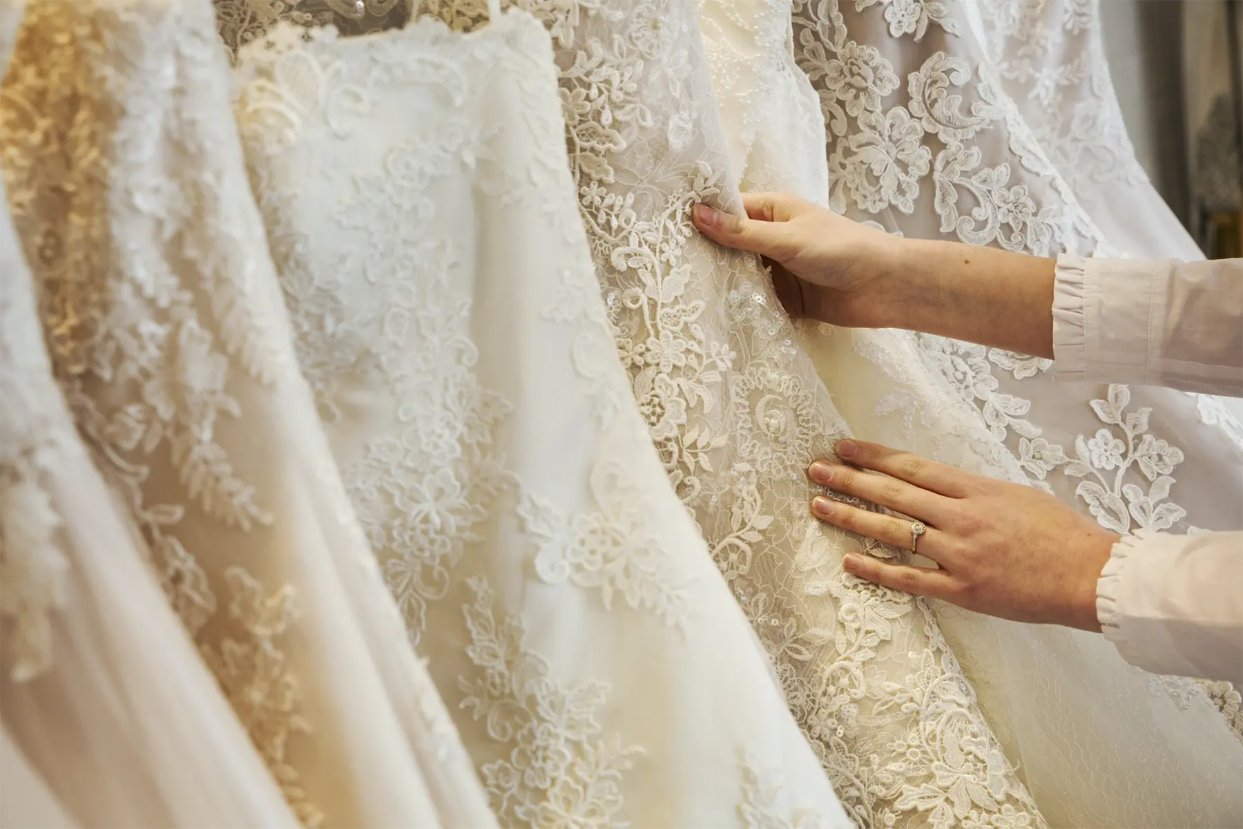 Hands selecting from different fabric options in a bridal boutique