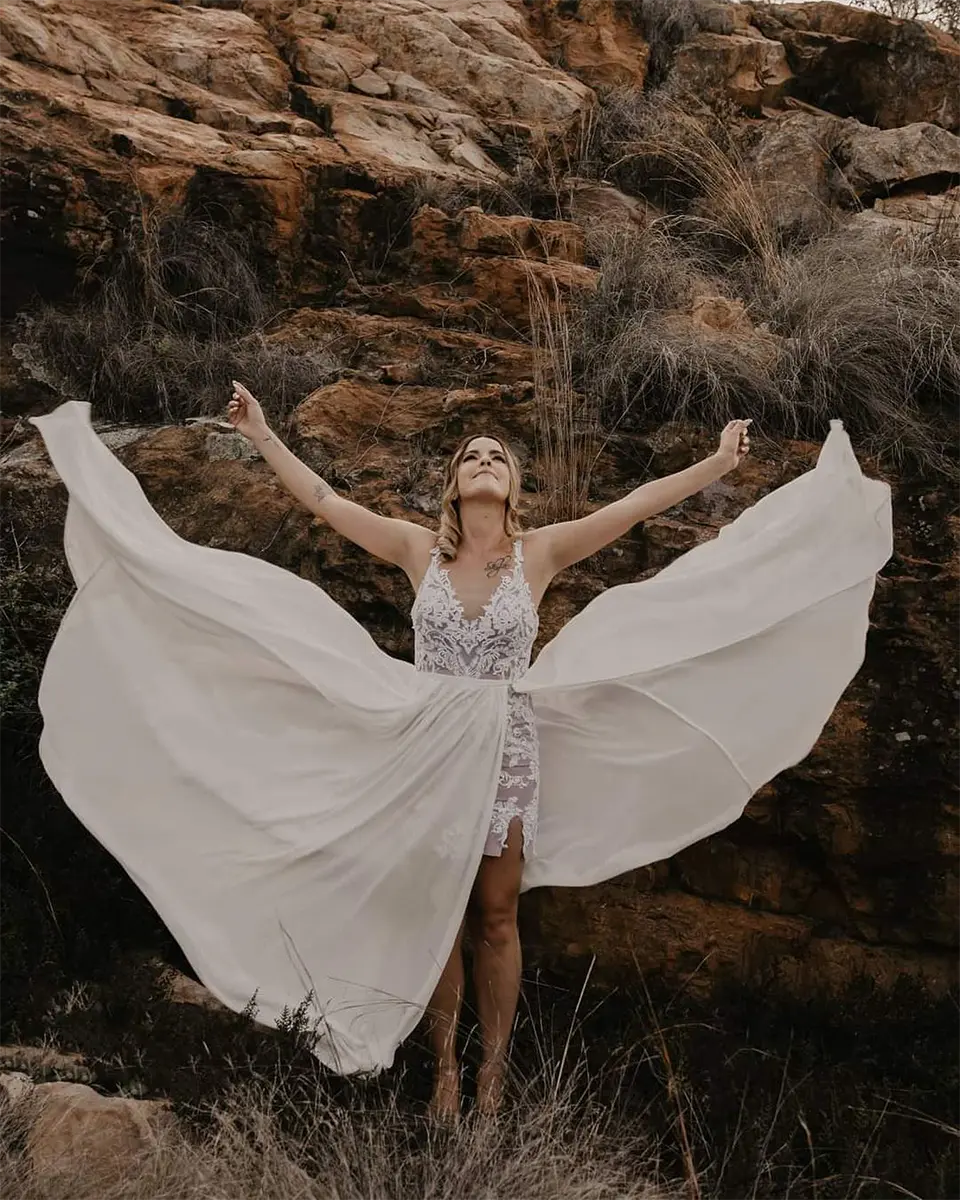 Casey posing with her custom wedding dress flowing dramatically in motion
