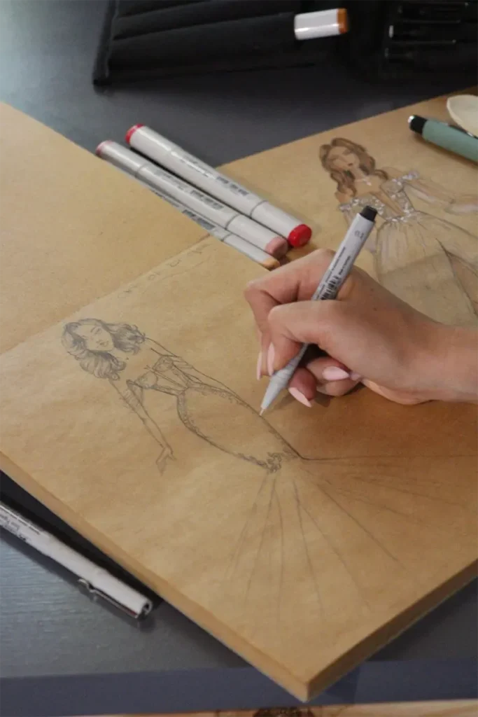 Wedding dress designer sketching a custom wedding dress concept by hand
